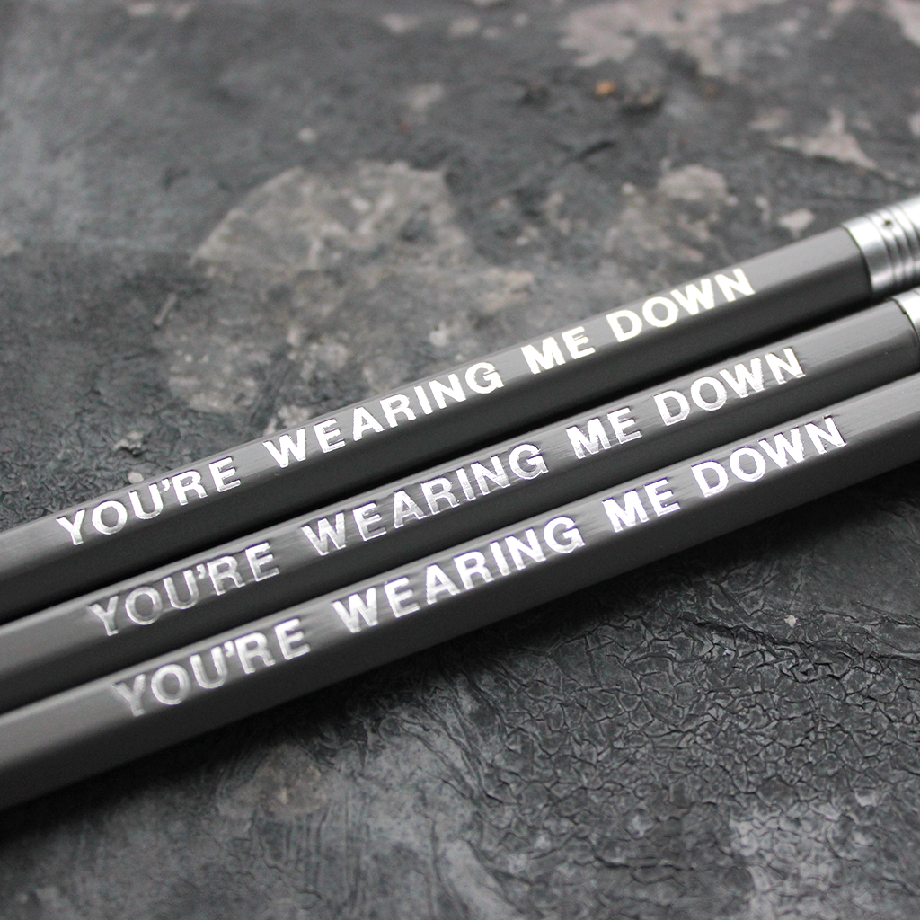 Grey pencils with a silver foil blocked message that says You're Wearing Me Down