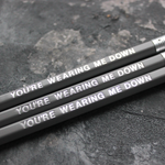 Grey pencils with a silver foil blocked message that says You're Wearing Me Down