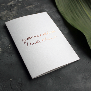 this luxury card says 'you're weird i like that' and is handwritten and hand printed in rose gold foil