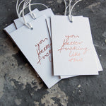 This cash card saPack of gift tags say You Better Fucking Like This  handwritten and hand printed in rose gold foil on white luxury paper on grey board