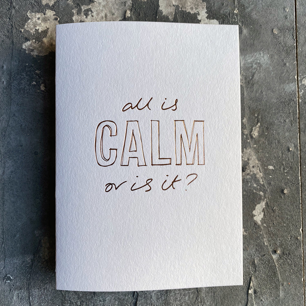 This luxury Christmas Card has a hand written rose gold foil block message saying All Is Calm Or Is It? on the front