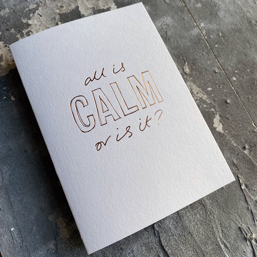 This luxury Christmas Card has a hand written rose gold foil block message saying All Is Calm Or Is It? on the front
