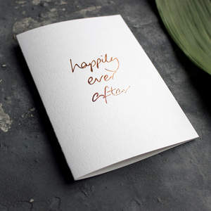 A rose gold hand foiled card saying Happily Ever After perfect a wedding