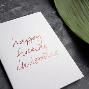Happy Fucking Christmas card is handwritten in rose gold foil blocking on white card