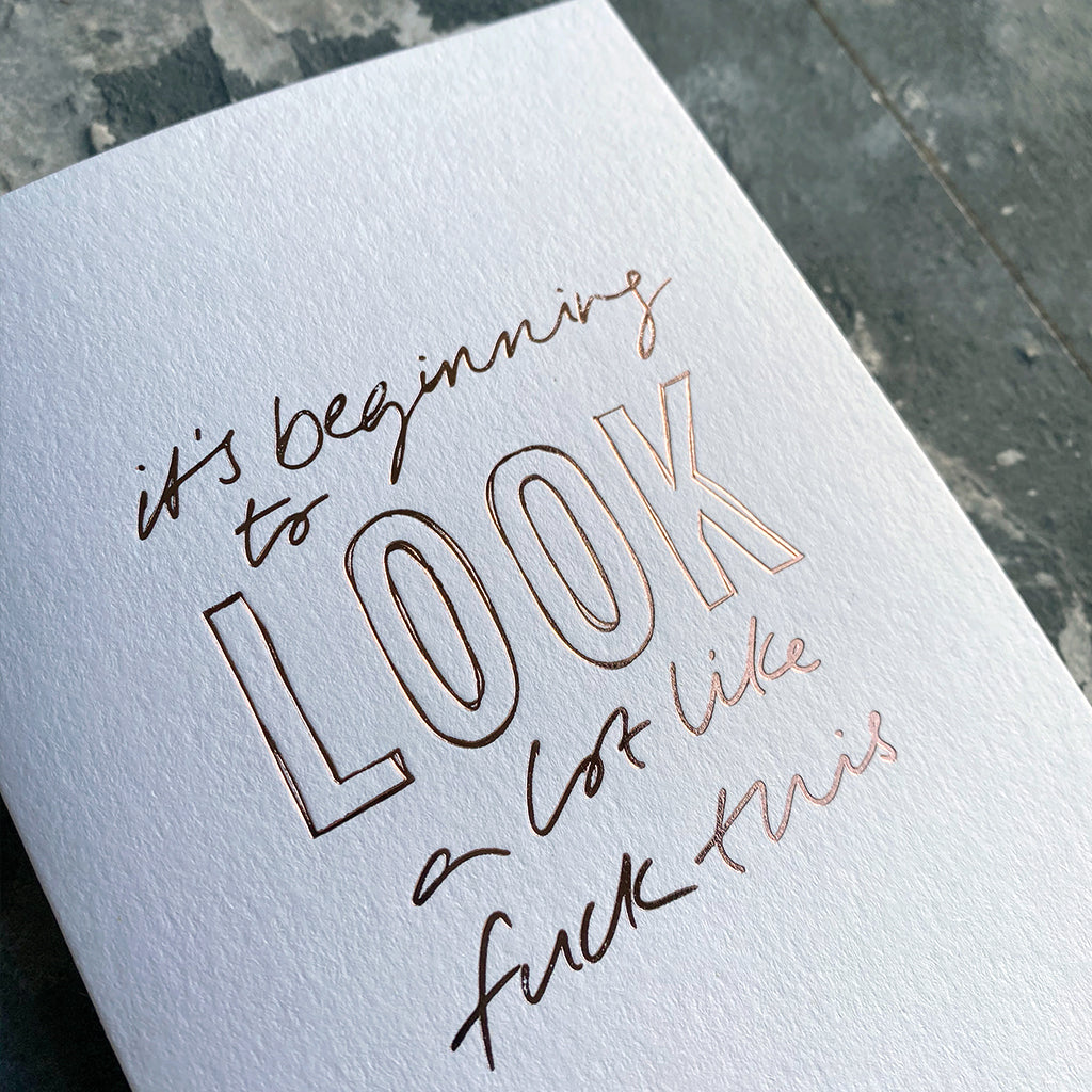 This luxury Christmas Card has a hand written rose gold foil block message saying It's Beginning To Look A Lot Like Fuck This on the front