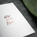 this luxury wedding card that's handwritten with a rose gold foil message saying mr and mrs