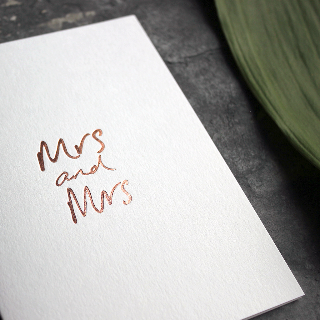 this luxury wedding card for the gay couple says Mrs and Mrs on the front, handwritten and hand foiled in rose gold
