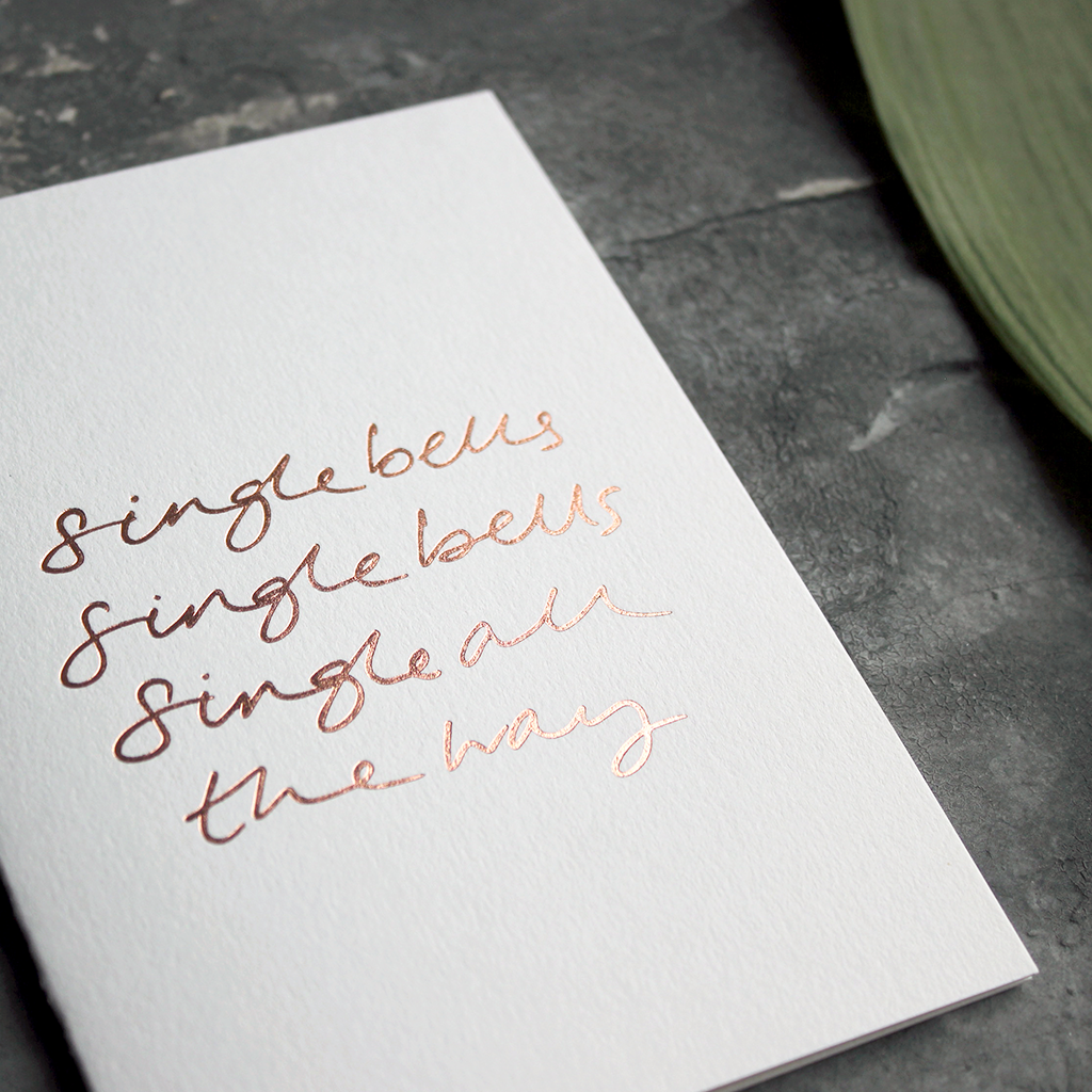a rose gold foil christmas card says single bells single bells single all the way on the front