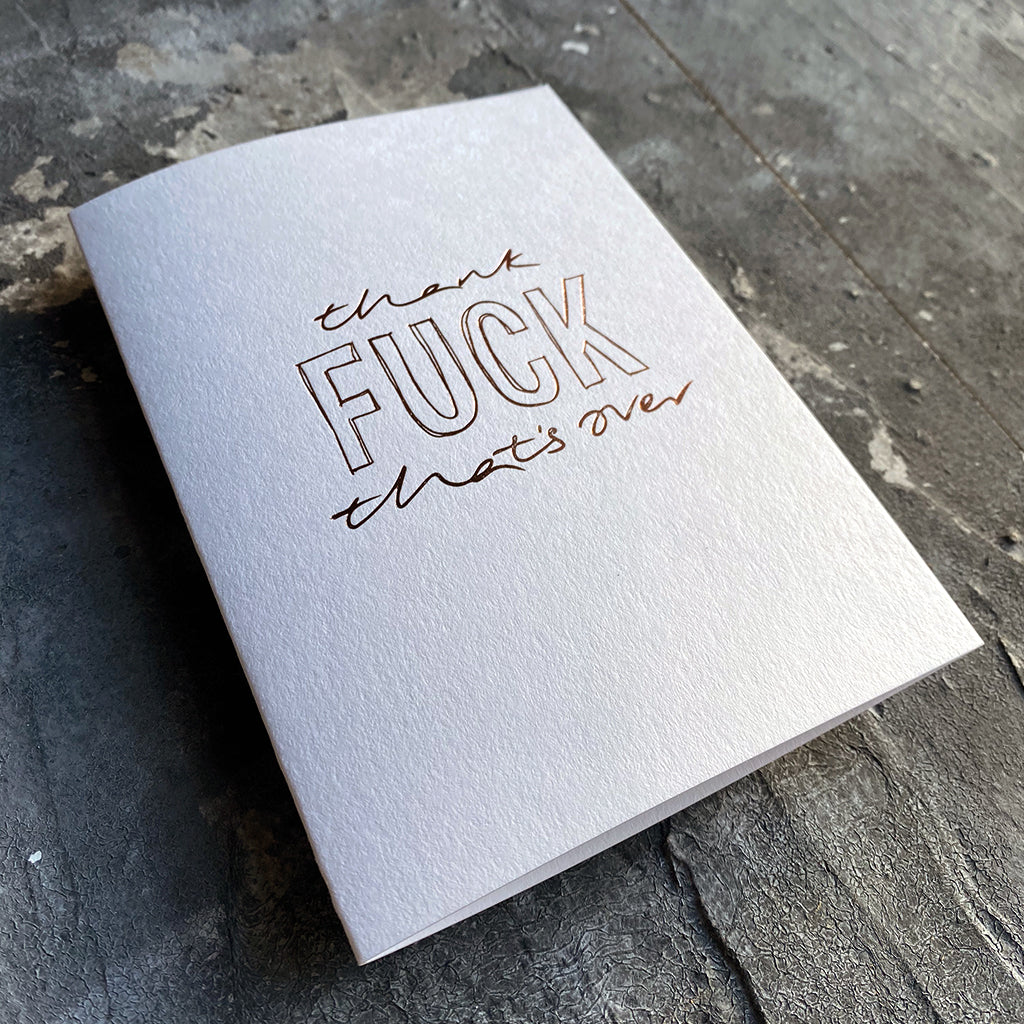 This luxury Christmas Card has a hand written rose gold foil block message saying Thank Fuck That's Over on the front